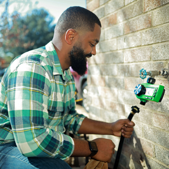 Man installing hose end timer
